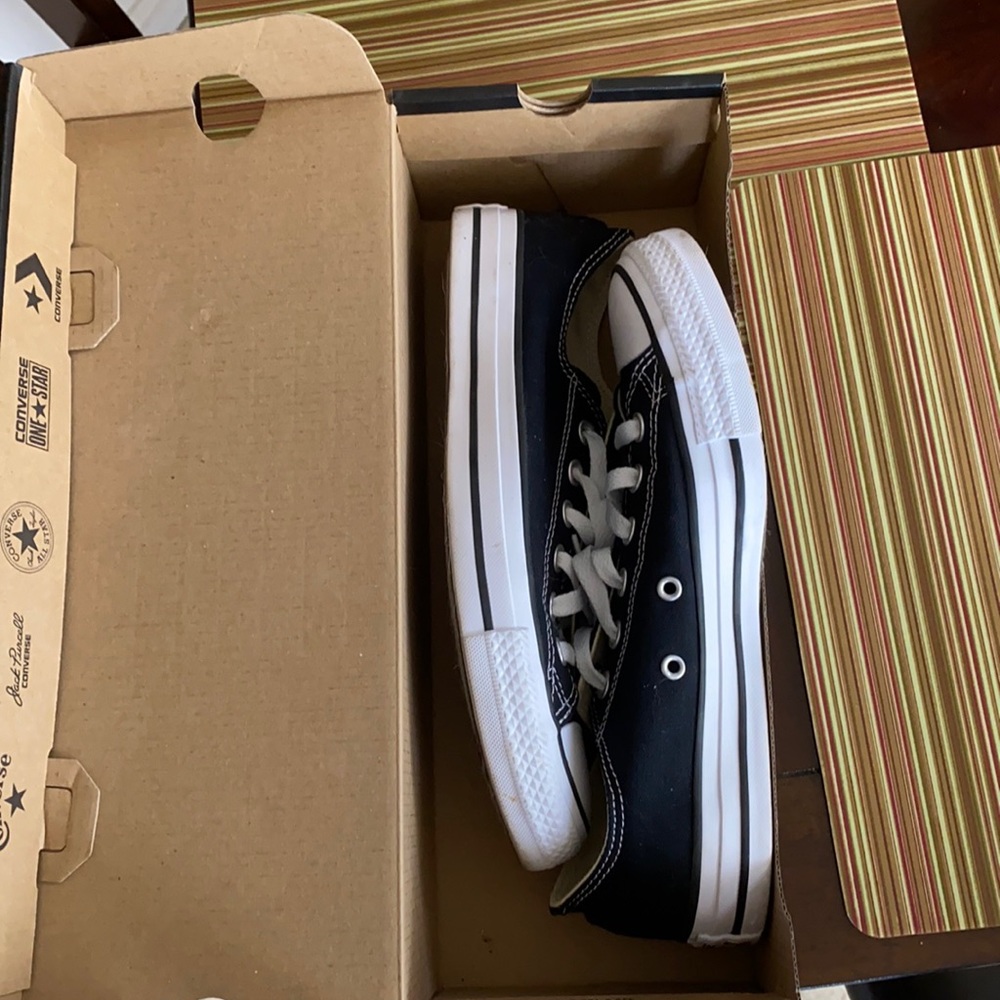 Women’s black and white low top converse sneakers.